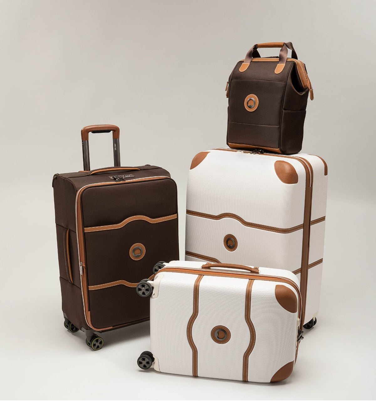 Delsey Chatelet luggage in several sizes, brown and cream with tan trim, stacked together